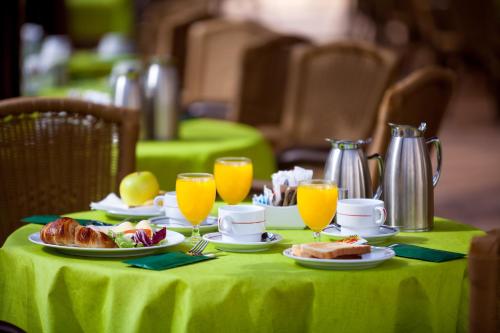 een tafel met een groene tafelkleed met eten en sinaasappelsap bij Apartamentos Casablanca in Puerto de la Cruz