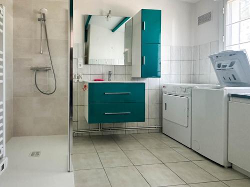 une salle de bain avec des armoires vertes et une laveuse et une sécheuse dans l'établissement Maison 3 chambres à La Palmyre - Près de la mer, Parking, WIFI, Animaux admis - FR-1-705-14, à La Palmyre