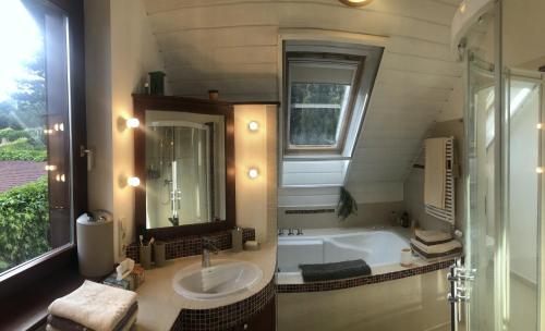 a bathroom with a tub and a sink and a mirror at Sajkod-az Öböl Csendje in Tihany