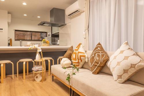 a living room with a couch and a kitchen at 桜の川38 新宿渋谷に直結 幡ヶ谷一戸建 2-11人丨 connected to Shinjuku and Shibuya House 2-11 people in Tokyo