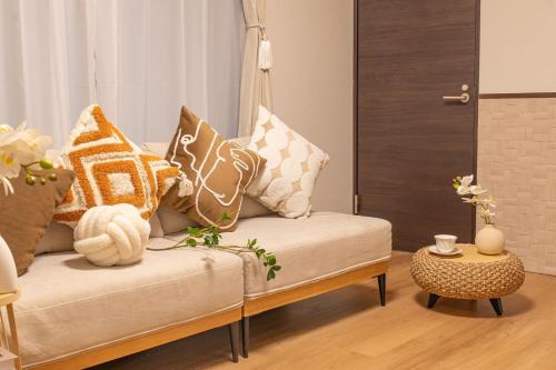 a living room with a couch with pillows on it at 桜の川38 新宿渋谷に直結 幡ヶ谷一戸建 2-11人丨 connected to Shinjuku and Shibuya House 2-11 people in Tokyo
