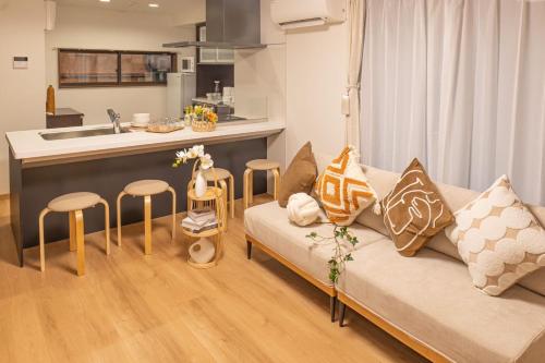 a living room with a couch and a kitchen at 桜の川38 新宿渋谷に直結 幡ヶ谷一戸建 2-11人丨 connected to Shinjuku and Shibuya House 2-11 people in Tokyo