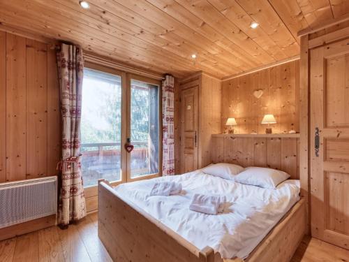 Ce lit se trouve dans une chambre en bois dotée d'une fenêtre. dans l'établissement Chalet familial 12 pers à Saint-Gervais, parking, vue Mont-Blanc - FR-1-663-27, à Saint-Gervais-les-Bains