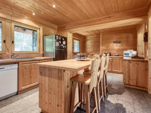 une cuisine avec des armoires en bois et un grand îlot en bois dans l'établissement Chalet familial 12 pers à Saint-Gervais, parking, vue Mont-Blanc - FR-1-663-27, à Saint-Gervais-les-Bains