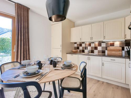 une cuisine avec une table en bois et des chaises ainsi qu'une salle à manger dans l'établissement Charmant appartement rénové au centre avec jardin et parking, idéal pour 4 personnes - FR-1-663-34, à Saint-Gervais-les-Bains