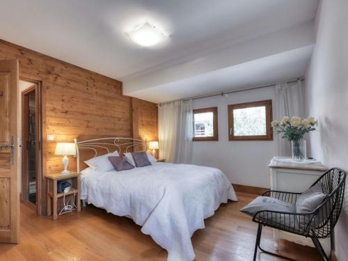 une chambre avec un grand lit et une chaise dans l'établissement Duplex à Saint-Gervais, 4 chambres, 8 pers, parking et WiFi - FR-1-663-36, à Saint-Gervais-les-Bains
