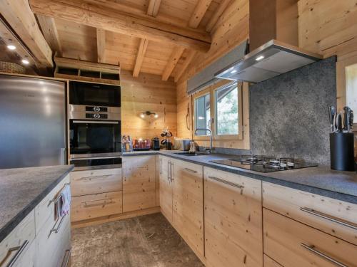 une grande cuisine avec des armoires en bois et une cuisinière dans l'établissement Chalet 8 pers à Saint-Gervais, proche pistes, parking, wifi, jardin - FR-1-663-29, à Saint-Gervais-les-Bains