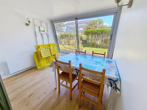 une salle à manger avec une table et des chaises et une fenêtre dans l'établissement Appartement Rez-de-Jardin Proche Mer, 4 Couchages - FR-1-746-31, à Bernières-sur-Mer