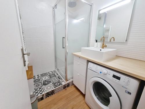 une salle de bain avec une machine à laver et un lavabo dans l'établissement Appartement Rez-de-Jardin Proche Mer, 4 Couchages - FR-1-746-31, à Bernières-sur-Mer