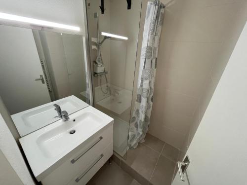 une salle de bain blanche avec un lavabo et une douche dans l'établissement Appartement climatisé pour 2 pers avec parking proche plage - FR-1-338-618, à Sète