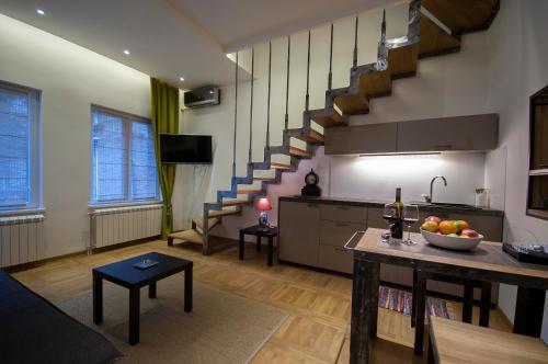 un soggiorno con cucina e una scala di Green and Blue Garden Apartments a Belgrado