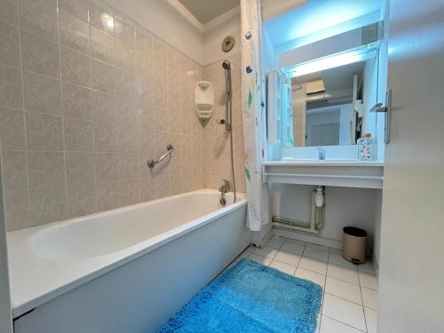 a bathroom with a tub and a sink and a mirror at Appartement 3 pièces, vue mer, parking, climatisation à Sète - FR-1-338-620 in Sète