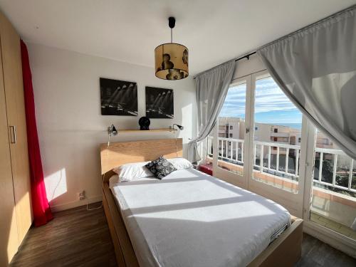 une chambre avec un lit et une grande fenêtre dans l'établissement Appartement pour 4 face à la mer avec parking privé, à Sète - FR-1-338-619, à Sète