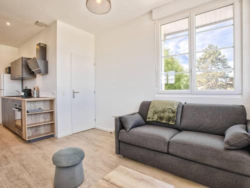 un salon avec un canapé et une fenêtre dans l'établissement Appartement lumineux avec 2 balcons à 600m de la plage - FR-1-788-78, à Merville-Franceville-Plage