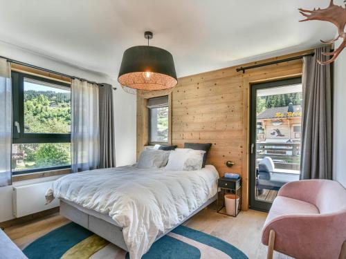 une chambre avec un lit, une chaise et des fenêtres dans l'établissement Chalet T4 spacieux 6-8 pers. avec vue sur les pistes - FR-1-685-88, aux Gets