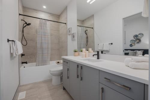 ein weißes Badezimmer mit Toilette und Dusche in der Unterkunft Fenced Yard, Free Parking, 2 King Beds with AC in Calgary