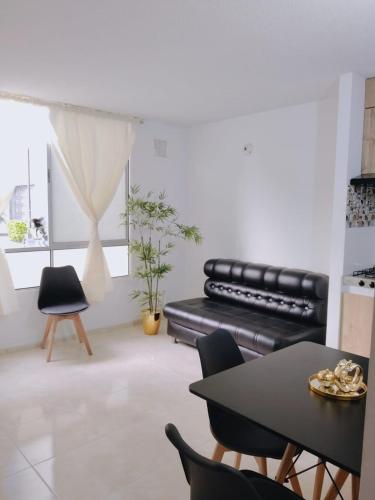 a living room with a black leather couch and chairs at Apartamento cómodo y con excelente ubicación in Cúcuta