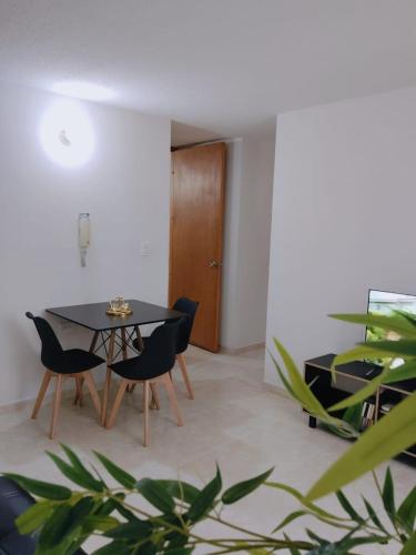 a dining room with a black table and chairs at Apartamento cómodo y con excelente ubicación in Cúcuta