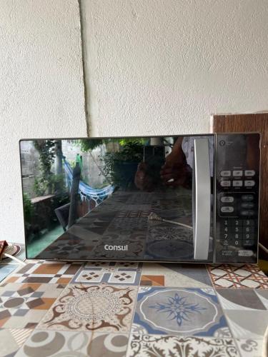 a microwave with a picture of a person in it at Casa aconchegante em Barra de Caravelas in Caravellas