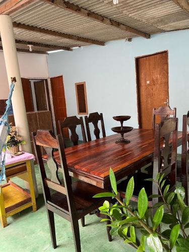 a dining room with a wooden table and chairs at Casa aconchegante em Barra de Caravelas in Caravellas