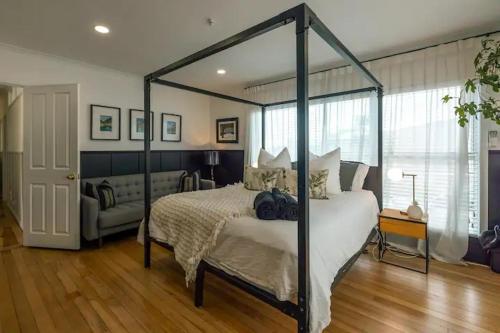 a bedroom with a canopy bed and a couch at Palm Springs in Waiheke Island