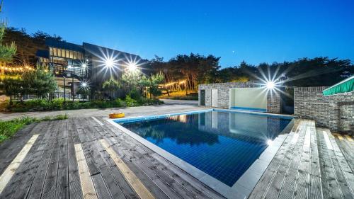 a swimming pool in front of a building with lights at Gyeongju Byeolgwadaliyagi Dog-friendly pension in Gyeongju