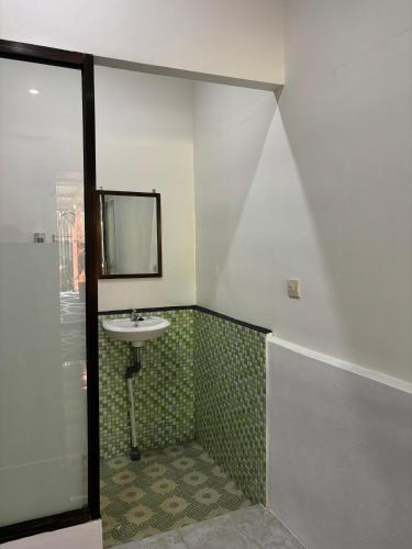 a bathroom with a sink and a mirror at Dimas Cottage in Senaru