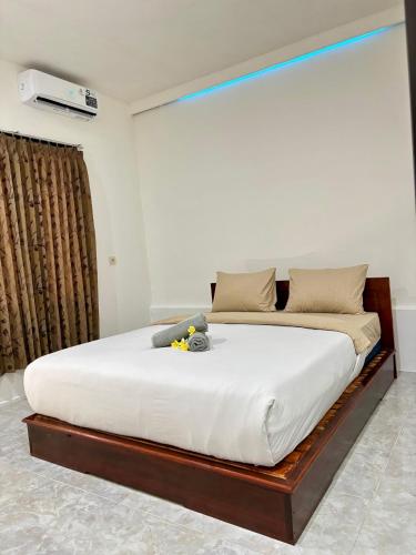 a bedroom with a large bed with white sheets at Dimas Cottage in Senaru