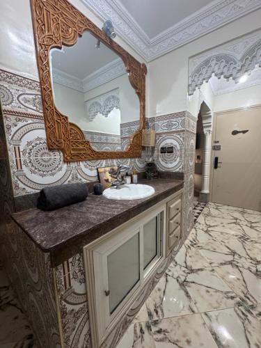 a bathroom with a sink and a large mirror at Airport Apartment 5 minutes walk, perfect for Early & Late Flights in Marrakech