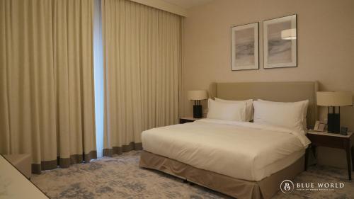 a hotel room with a bed and a window at Address Beach Resort Fujairah Apartment Three Bedrooms by Blue World- 1 in Fujairah