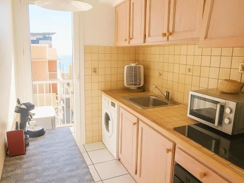 une cuisine avec un évier et un micro-ondes dans l'établissement Appartement T2 avec Climatisation à Argelès-sur-Mer - FR-1-732-96, à Argelès-sur-Mer