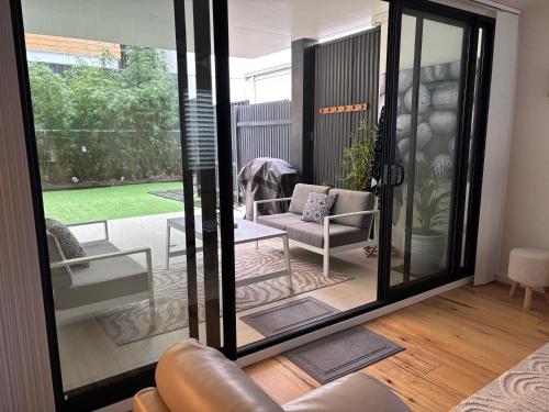 a living room with a sliding glass door at Sandy Paws and Salty Zoomies in Huskisson