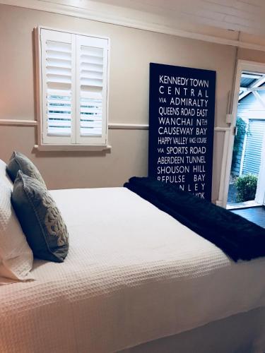 a bedroom with a bed with a sign on the wall at The Bakers Cottage in Armidale