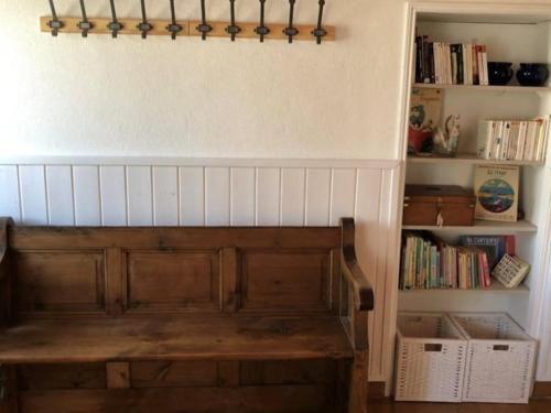 un escalier avec un banc en bois dans une pièce avec des livres dans l'établissement Maison ensoleillée proche plages à 200m - FR-1-813-22, à Groix