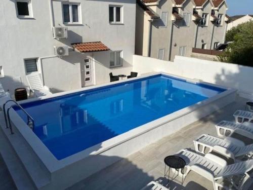 Una gran piscina azul al lado de un edificio en Villa Brazza - Studio Apartment, en Milna