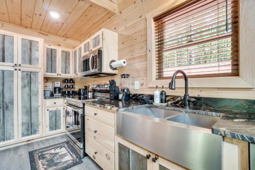 a kitchen with a stainless steel sink and wooden cabinets at Sip, Hike and Explore Sleek Retreat in Cleveland! in Cleveland