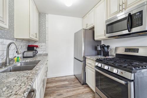 a kitchen with stainless steel appliances and white cabinets at Beautiful 2 Bed Beach Condo #203 in Carpinteria