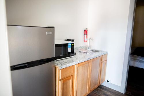 a kitchen with a stainless steel refrigerator and a sink at The IronHorse Inn in Garden City
