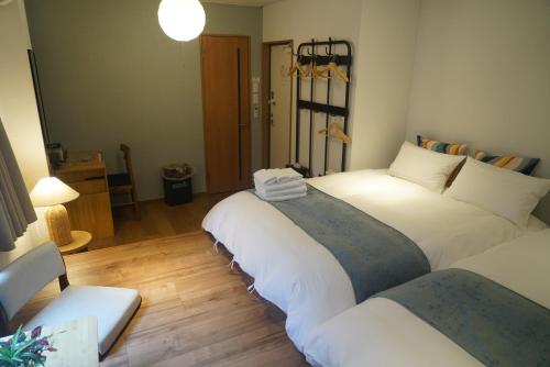 two beds in a room with wooden floors at Softlight Inn Asakusa Tokyo in Tokyo