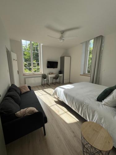 a bedroom with a bed and a couch at Maison d'hôtes La Bambouseraie in Thierville-sur-Meuse