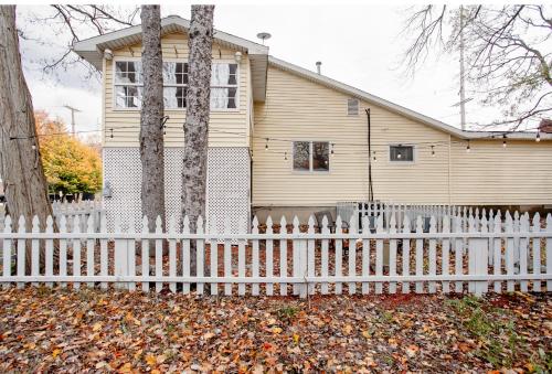a white picket fence in front of a house at Sleepy Owl Chalet 