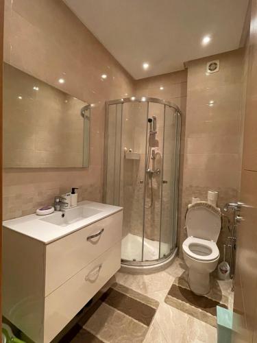 a bathroom with a shower and a toilet and a sink at Appartement Cosy Bouznika, plage proche in Bouznika