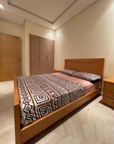 a bedroom with a large bed in a room at Appartement Cosy Bouznika, plage proche in Bouznika