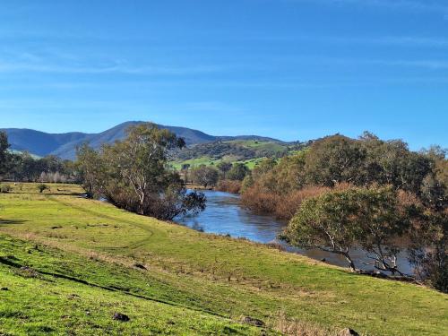 a river in the middle of a field with trees at Bimbimbi Experiences 