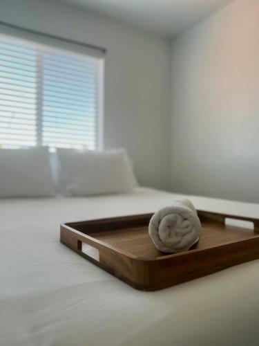 a wooden tray with a towel on top of a bed at By Popular Demand - Richmond in Richmond