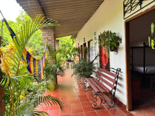 a bench sitting on a porch with plants at La Casa del Viajero Mompos in Mompos