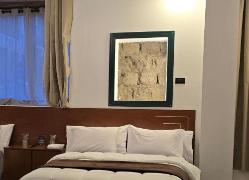 a bedroom with a bed with a picture on the wall at Hotel del Tren Boutique in Alausí