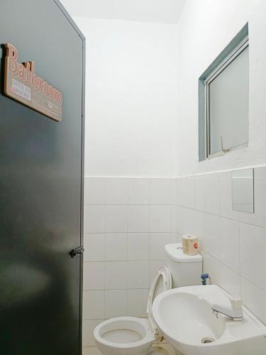 a bathroom with a toilet and a sink at Life HomeS in Lahad Datu