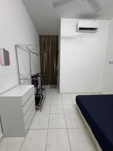 a white bedroom with a bed and a white tile floor at Homestay D BBSE in Simpang Empat