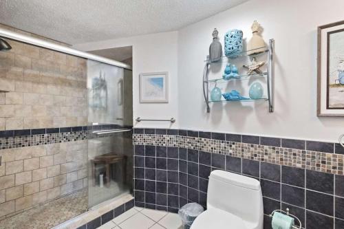 a bathroom with a toilet and a glass shower at Luxury Penthouse near Beach Tiki Hut Coligny in Hilton Head Island